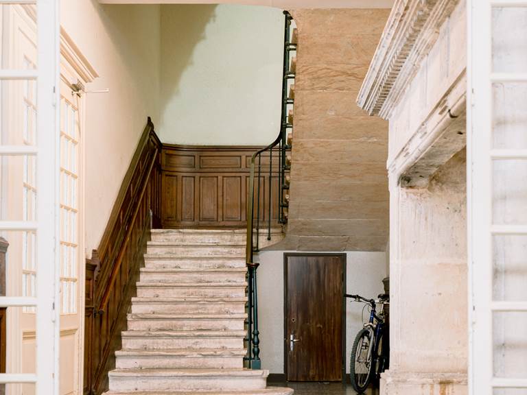 vue charmante de l'ancien escalier en pierre d'e´poque de l'Oasis d'Albi agre´mente´ de moulures en bois dans l'entre´e inte´rieure. Un mariage authentique d'histoire et de´le´gance
