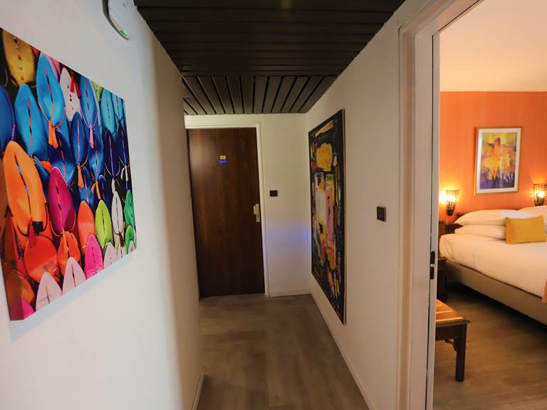 Couloir avec tableaux et chambre triple petit balcon