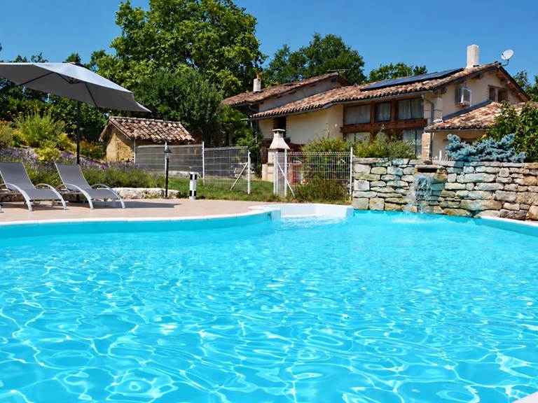 Piscine, cascade et transats gris