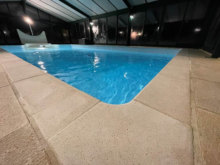 Grande piscine couverte éclairée le soir