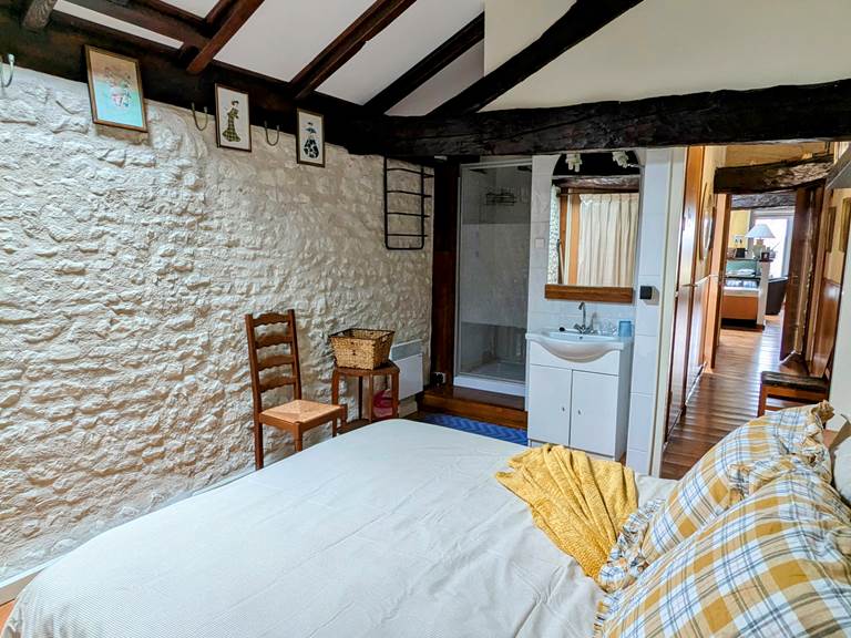 Cozy bedroom with vaulted ceiling, exposed beams and skylight at Secret de Campagne, Jaulnay Gites de Famille.