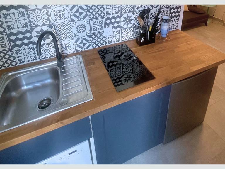 Cuisine du studio – Équipements modernes et ambiance cosy Plaque vitrocéramique, lave-vaisselle, rangements astucieux et décoration soignée pour un séjour sans contrainte au cœur de l’île de Ré.