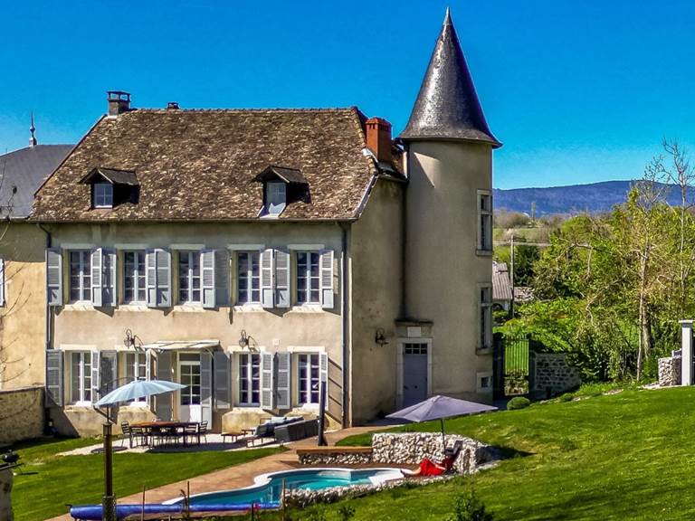 Façade jardin du Manoir du Colombier avec piscine et paysage naturel des montagnes du Bugey.