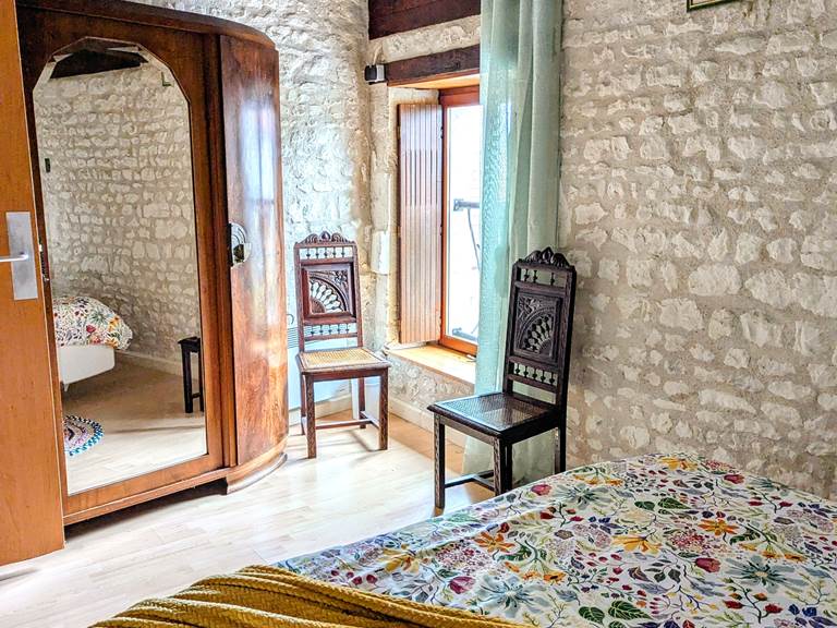 Antique mirrored armoire in the rustic bedroom at Secret de Campagne, Jaulnay Gites de Famille.