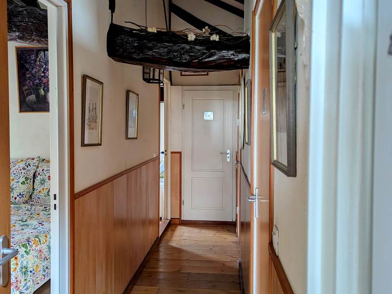 Cozy corridor with wooden beams leads to the 3 bedrooms and 2 bathrooms at Secret de Campagne, Jaulnay Gites de Famille.