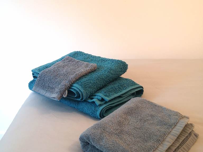 Ensemble de linge de maison composé de draps de lit, housse de couette, taie d'oreillers, serviette de bain et tapis de douche.