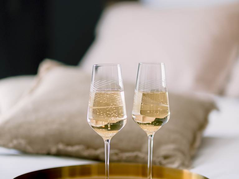 atmosphe`re de luxe avec deux coupes de champagne de´licatement pose´es sur un plateau dore´, agre´mentant e´le´gamment le lit king size de L'Oasis d'Albi