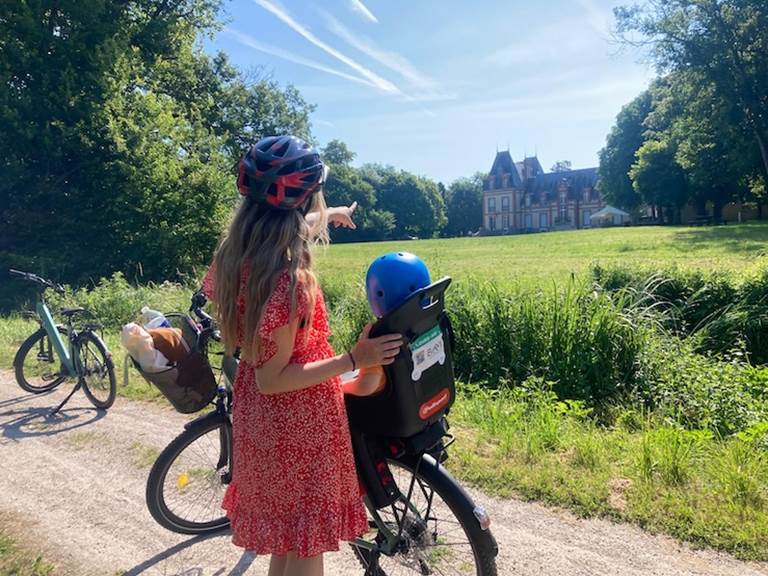 Cycliste et son enfant devant cha^teau