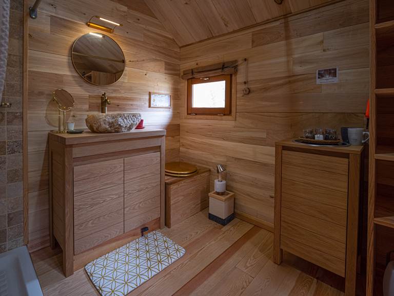 Salle de bain avec douche, lavabo et toilette sèche dans le zôme