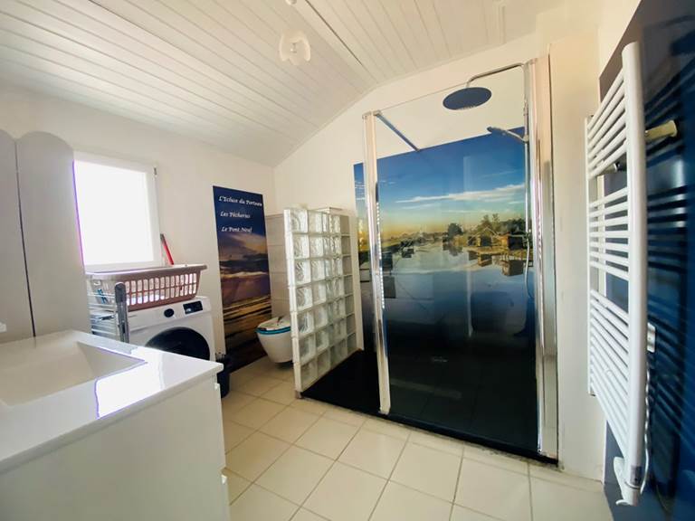 Salle d'eau avec pour toile de fond les Pêcheries du site du Porteau