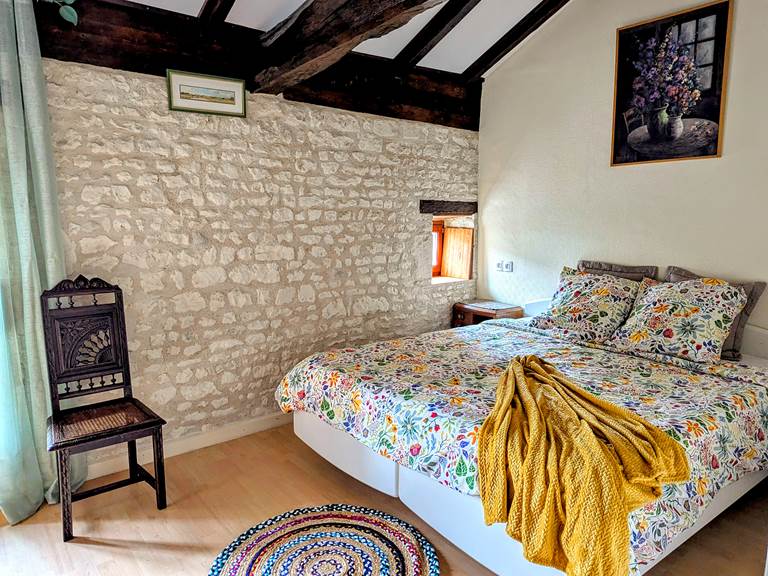 Tuffeau stone wall in the rustic bedroom at Secret de Campagne, Jaulnay Gites de Famille.