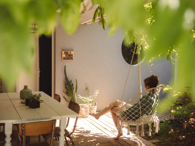 Sous le patio, se laisser bercer par la sérénité du lieu dans un fauteuil suspendu