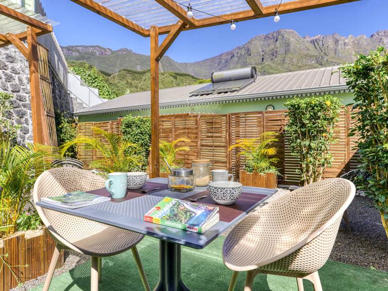 Terrasse arrière de l’appartement Bambou à Hell-Bourg, offrant une vue imprenable sur le Piton des Neiges et les montagnes verdoyantes de Salazie, à La Réunion.