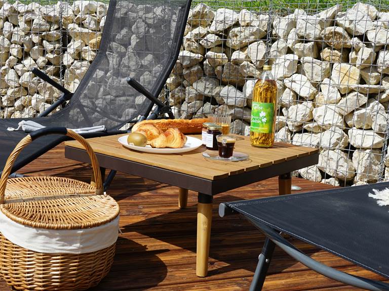 Panier petit déjeuner sur la terrasse du gîte 4 étoiles Le Manoir du Colombier, avec vue sur la nature du Bugey, au pied du Grand Colombier.