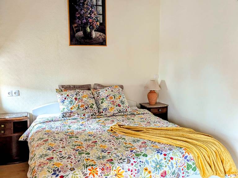 Sunshine glistens off the original wood beams in a rustic bedroom at Secret de Campagne, Jaulnay Gites de Famille.