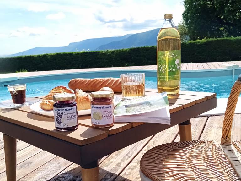 Matin gourmand au bord de la piscine du Manoir du Colombier, gîte 4 étoiles au pied du Grand Colombier.