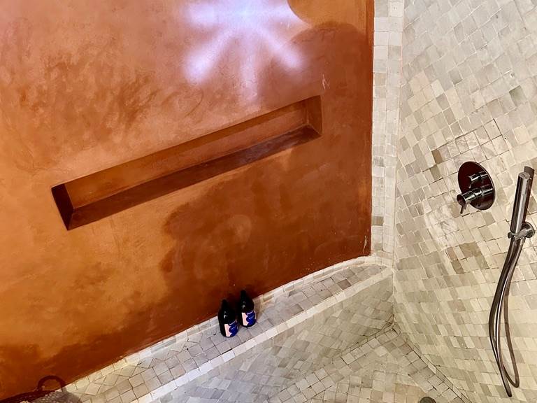 Rappels de matériaux traditionnels marocains, on retrouve le tadelakt et les zelliges dans la salle de bain