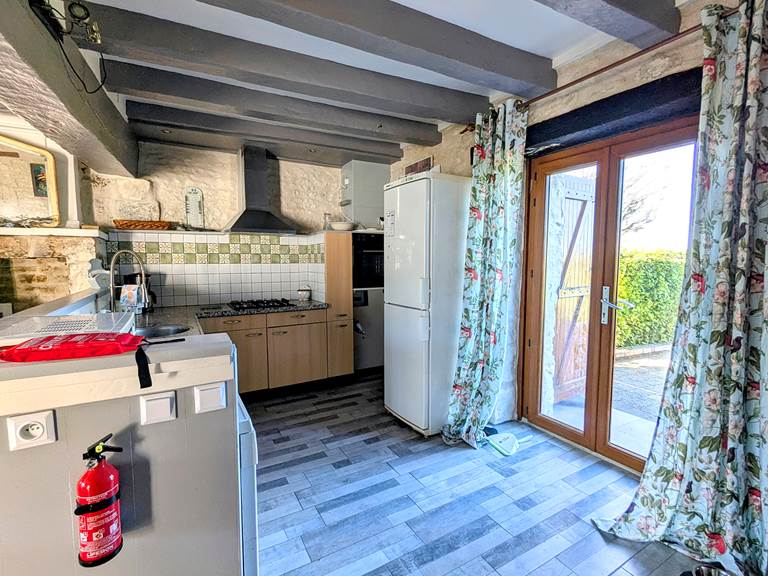 The kitchen at Tuffeau Sunsets, Jaulnay Gites de Famille, with a patio door leading to the back patio.