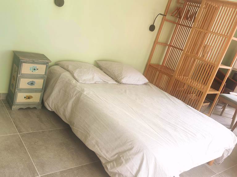 Chambre au style naturel et épuré Lit double, mobilier en bois clair et ambiance douce : parfait pour un séjour reposant au cœur de La Flotte.