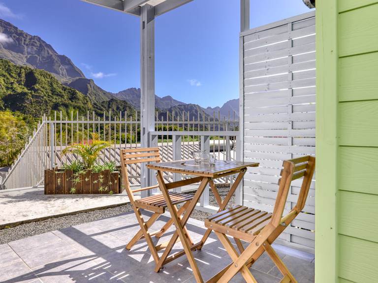 Terrasse avant du Cocon d’Hell-Bourg offrant une vue imprenable sur le Piton des Neiges et les montagnes verdoyantes du cirque de Salazie.