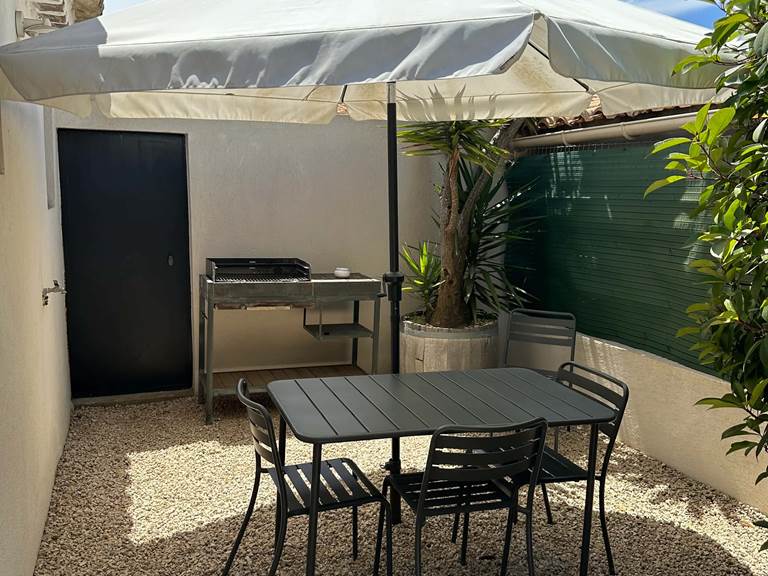 Coin repas ombragé avec barbecue pour des grillades conviviales