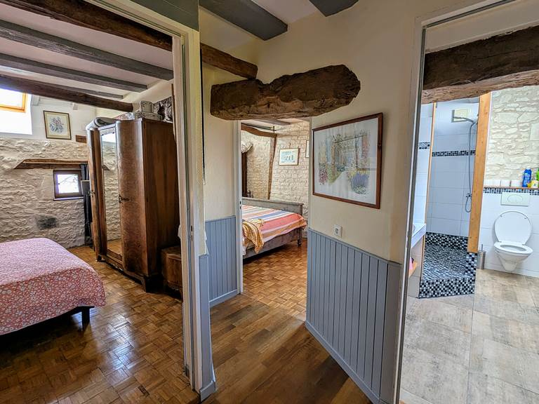 First floor landing with exposed beams leads to two bedrooms and a bathroom at Tuffeau Sunsets, Jaulnay Gites de Famille.