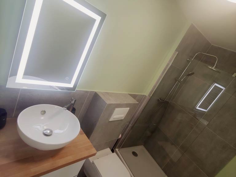 Salle d’eau contemporaine dans un esprit épuré Miroir rétroéclairé, vasque élégante et douche italienne : un espace bien pensé pour votre confort quotidien.