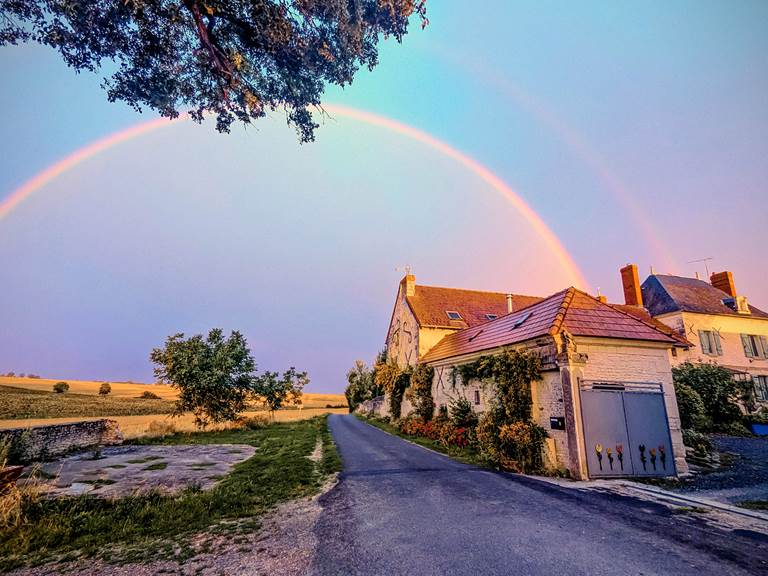 A rainbow shines over the front entrance of Jaulnay Gites de Famille, inviting families to enjoy the year-round beauty of nature.