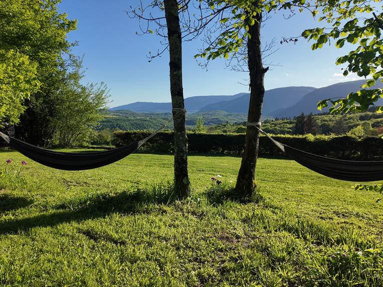 Détente dans les hamacs du Manoir du Colombier avec vue époustouflante sur les montagnes, gîte 4 étoiles au pied du Grand Colombier.