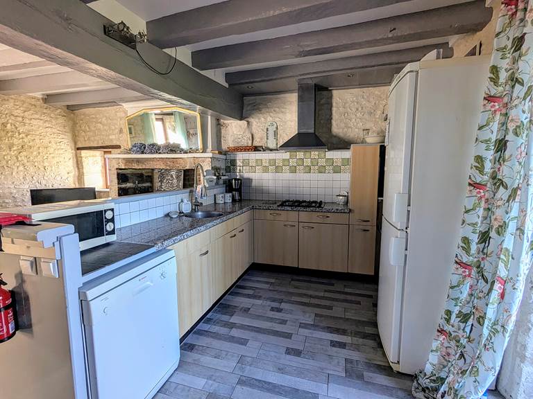 The fully equipped kitchen at Tuffeau Sunsets, Jaulnay Gites de Famille. includes a dishwasher, fridge, and cooktop.