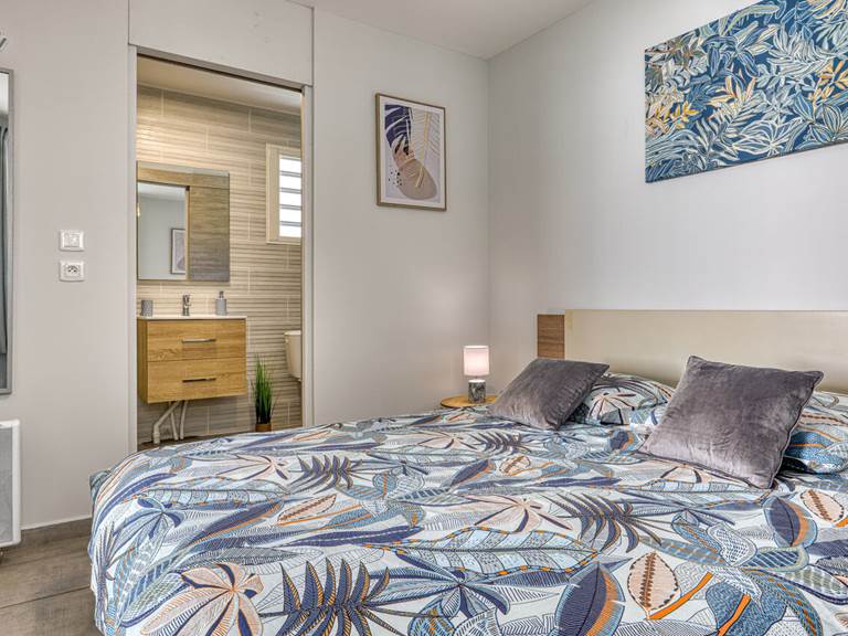 Chambre du Cocon d’Hell-Bourg avec lit queen size et salle d’eau attenante, alliant confort et élégance au cœur du cirque de Salazie, à La Réunion.