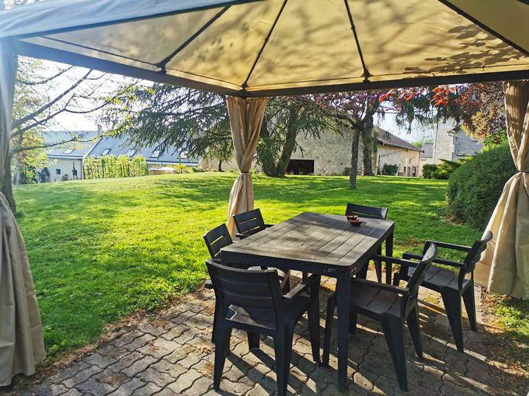 Coin repas extérieur dans le jardin arboré