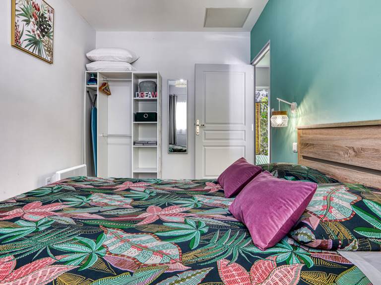 Chambre de l’appartement Chouchou à Hell-Bourg, équipée d’une literie queen size et d’un dressing, offrant confort et praticité pour votre séjour à Salazie, La Réunion.