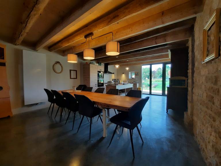 La table et les chaises sont installées tout près de la cuisine équipée.