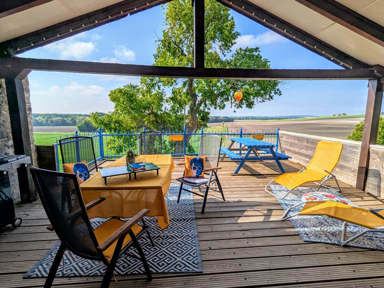 Yellow seating with views of farm fields at Secret de Campagne, Jaulnay Gites de Famille.