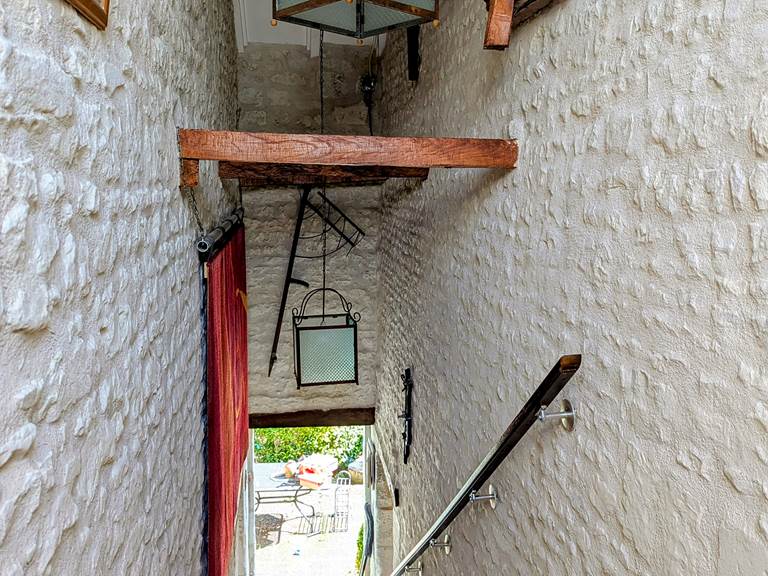 Soaring ceilings and original wood beams over the original stone staircase at Tuffeau Sunsets, Jaulnay Gites de Famille.