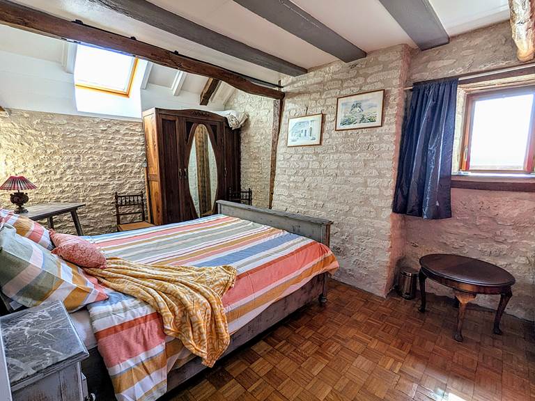 Bedroom with exposed stone and upper part of the chimney Tuffeau Sunsets, Jaulnay Gites de Famille.