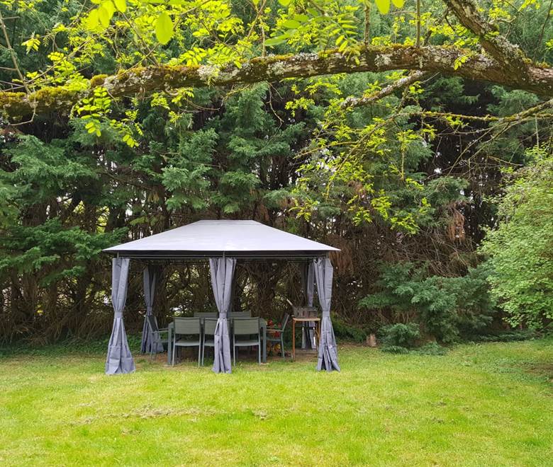 Pergola dans le jardin avec table pour 8 et BBQ