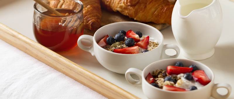 tasty-colorful-breakfast-with-oatmeal-yogurt-strawberry-blueberry-honey-milk-white-background-breakfast-bed-copy-space-top-view