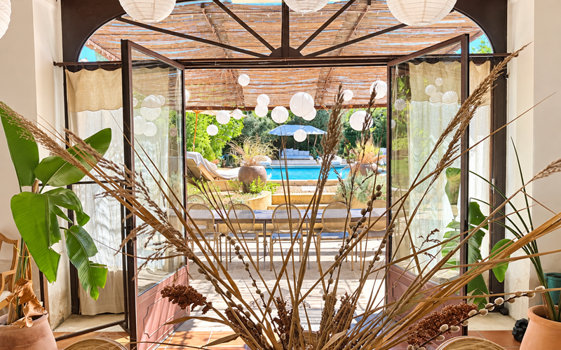 "Depuis l'Orangerie, le regard s'ouvre sur la terrasse et la piscine, au coeur du jardin"