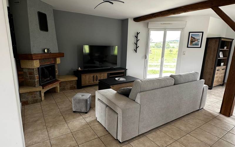 Salon convivial avec canapé, pouf et télévision