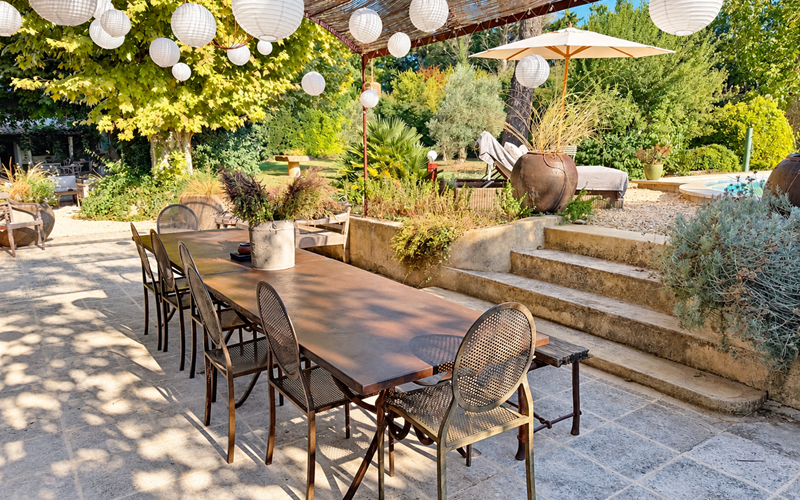 "La grande table de l'orangerie, à l'ombre de la pergola, entre jardin et piscine"