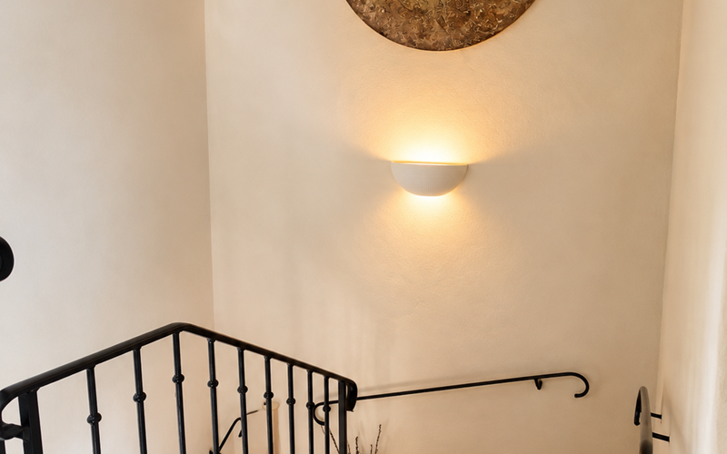 "L'escalier du Mas, entre les lignes anciennes et création artistique, mène doucement vers les chambres de l'étage."