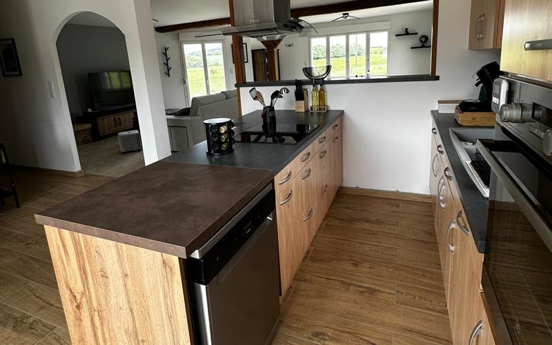 Cuisine moderne et tout équipée, ouverte sur le salon-salle à manger pour un séjour chaleureux et fonctionnel.