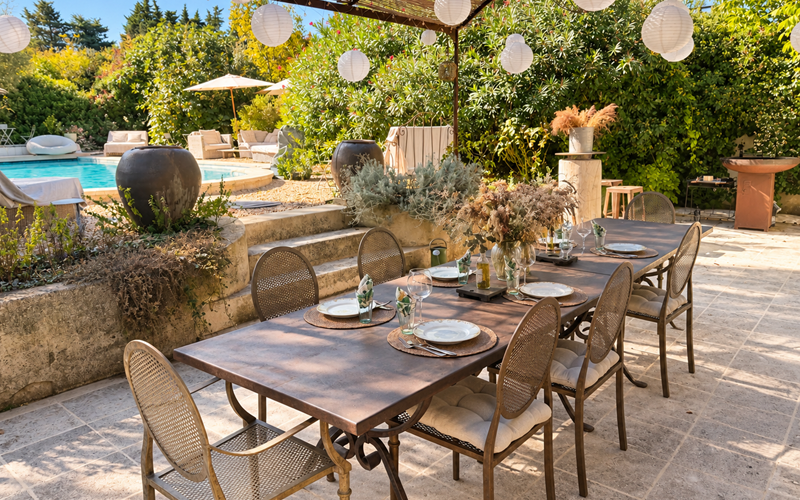 "À l'ombre de la pergola, déjeuners et moments de partage prennent place sur la terrasse de l'Orangerie, dans une atmosphère chic et bohème."