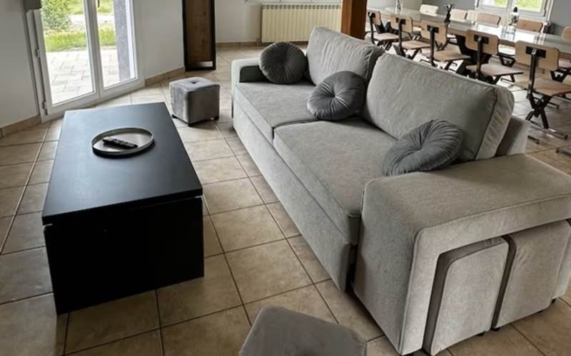 Un salon confortable équipé d’un canapé spacieux, de poufs et d’une télévision avec chaînes TV, idéal pour se détendre après une journée de découverte
