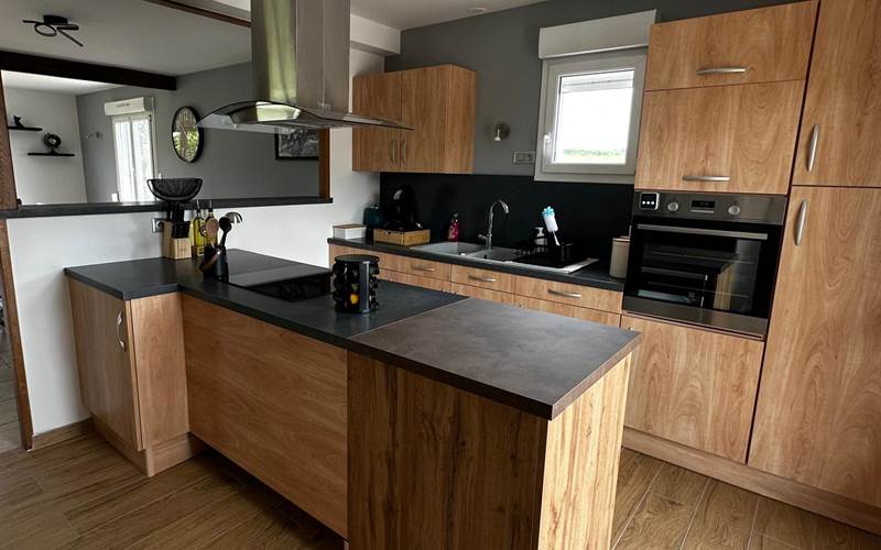 Cuisine moderne et tout équipée, ouverte sur le salon-salle à manger pour un séjour chaleureux et fonctionnel.