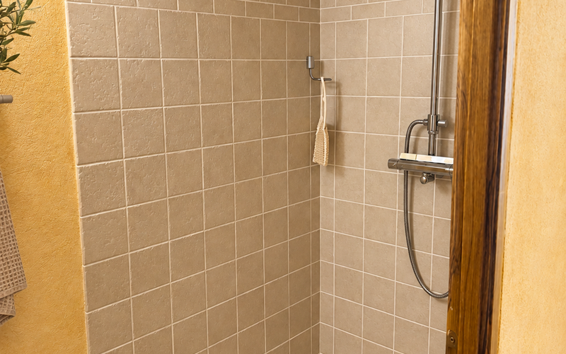 "Une douche spacieuse aux matières naturelles, dans l'esprit chaleureux de la Suite de l'Orangerie"