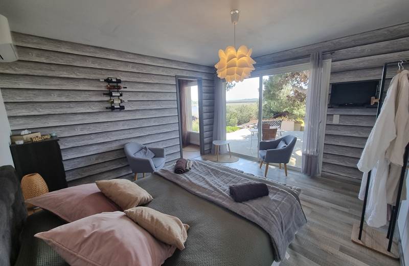 grande chambre avec coin salon séparée de la cuisine et de la salle d'eau