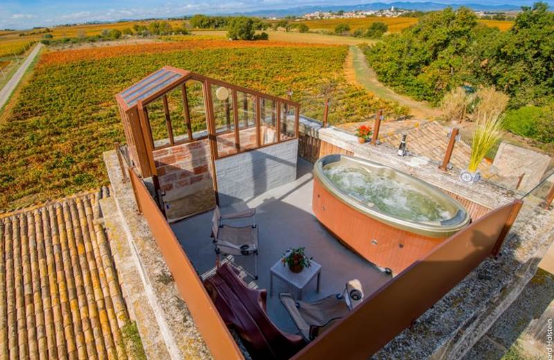 Jacuzzi avec vue panoramique sur les vignes dans une chambre romantique en Occitanie